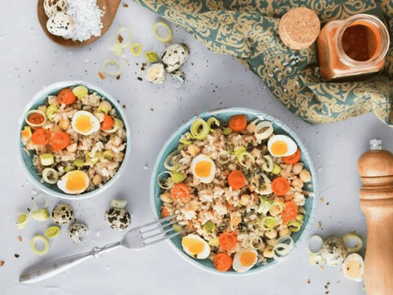 Ensalada de legumbres con atún servida en un bol con aliño de aceite de oliva y vegetales frescos.