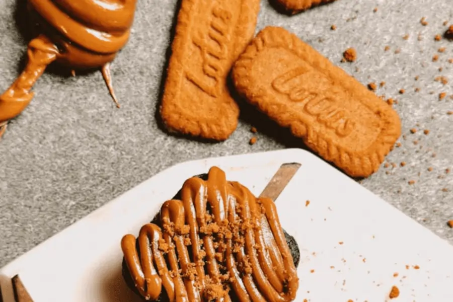 Galletas Lotus Biscoff crujientes servidas con una taza de café sobre una mesa rústica.
