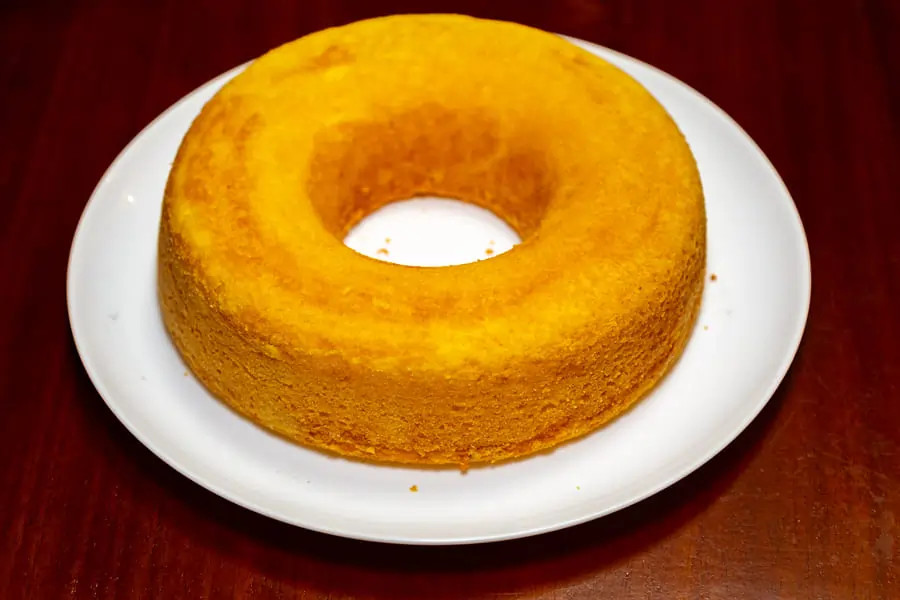 Bizcocho de yogur recién horneado sobre una rejilla, mostrando su textura esponjosa y dorada.
