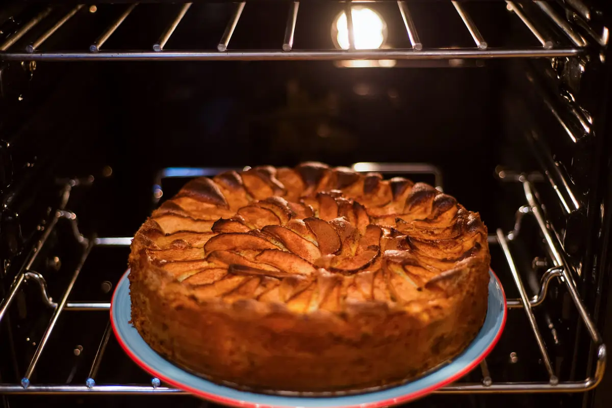 ¿Dónde se colocan los bizcochos en el horno? Bizcocho de manzana horneándose en la rejilla central del horno.